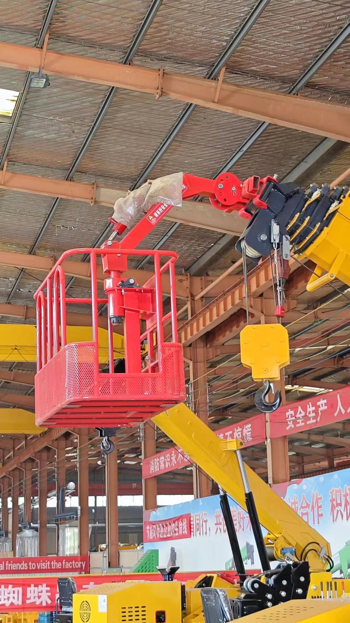 Risenmega spider crane fitted with a lifting basket for working at height on facade and maintenance jobs